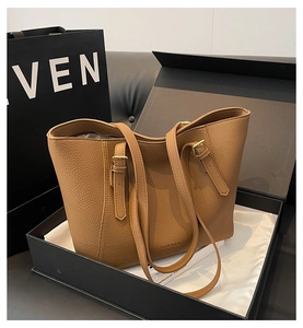 Détail d'un cabas en cuir grainé marron dans un coffret cadeau noir haut de gamme