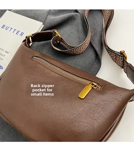 Détail du sac bandoulière en cuir marron avec poche arrière zippée et zip doré élégant
