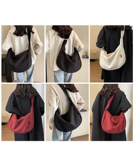 Vue arrière de mannequins portant de grands sacs demi-lune en toile noir, blanc et bordeaux