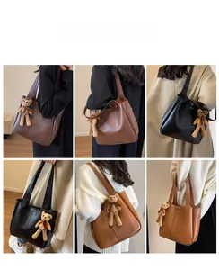 Detail shots of large leather tote bags in black and brown with bear charms