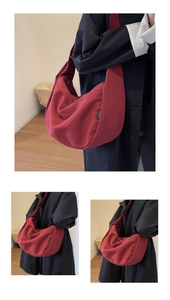 Détail du sac bandoulière demi-lune en toile bordeaux avec étiquette de marque TUAWETU