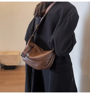 Détail du sac demi-lune marron vintage avec bandoulière jacquard et logo doré