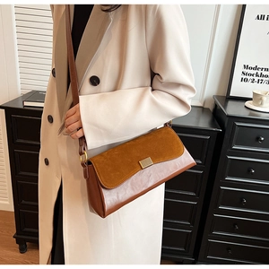 Close-up of caramel shoulder bag with matte suede texture and gold clasp detail