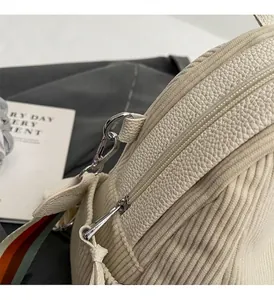 Detail of lychee leather and corduroy texture with striped strap and silver hardware