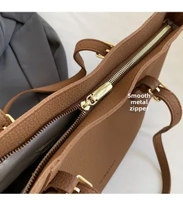 Détail de la fermeture éclair dorée et cuir marron texturé du grand sac cabas
