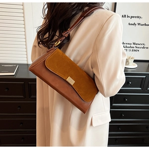 Side view of retro underarm bag with dark brown leather and caramel suede paneling