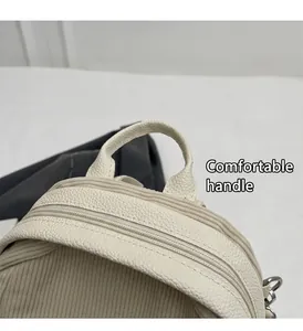 Detail view of corduroy and lychee grain PU leather stitching with smooth metal zipper