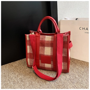 Detail der rot-weiß karierten Tragetasche mit Tweed-Textur und Ledergriffen
