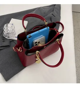 Top view of red large capacity handbag showing spacious interior and golden leaf charm