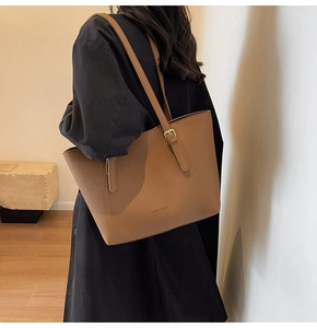 Détail du sac cabas en cuir marron à motif litchi avec boucle dorée et bandoulière