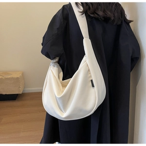 Détail latéral du sac hobo en velours côtelé blanc cassé montrant sa texture et sa forme