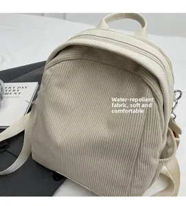 Close-up of cream corduroy backpack with leather trim and water-repellent fabric detail