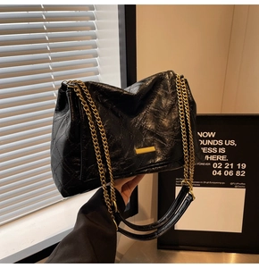 Détail du sac à bandoulière en cuir matelassé noir avec chaîne et plaque dorée
