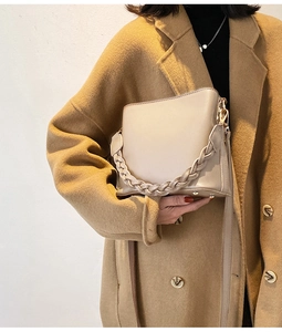 Détail du sac seau beige avec poignée tissée texturée et finition en similicuir lisse