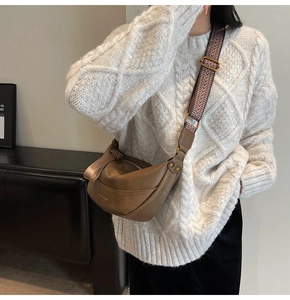 Sac bandoulière demi-lune en cuir marron avec large bandoulière tissée sur mannequin