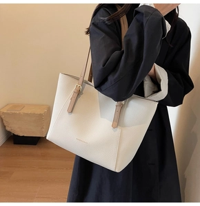 Vue détaillée du sac cabas beige grainé avec bandoulière marron réglable sur mannequin