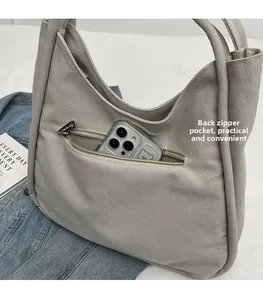 Detail of the back zipper pocket on a light grey canvas tote bag for secure storage