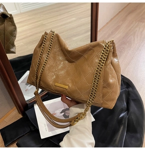 Gros plan du sac en cuir matelassé marron caramel avec chaîne dorée élégante