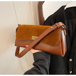 Close-up of caramel brown shoulder bag with suede拼接 texture and golden metal lock