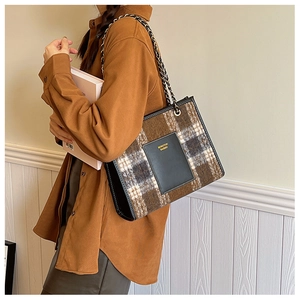 Detail of wool plaid tote bag with chain strap and leather trim for autumn fashion
