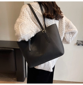 Détail du sac cabas noir en cuir grainé avec logo et finitions métalliques fines