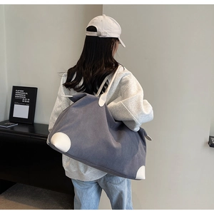 Detailed back view of grey corduroy tote bag with white leatherette trim and handles