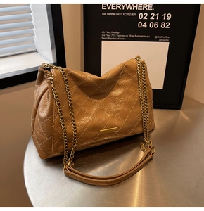 Détail du sac matelassé caramel avec bandoulière chaîne dorée et finitions métalliques