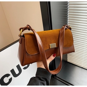 Detail of retro patchwork shoulder bag with brown leather and suede texture contrast