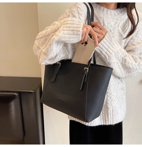 Détail d'un grand sac cabas en cuir grainé noir montrant sa capacité et l'imprimé FASHION