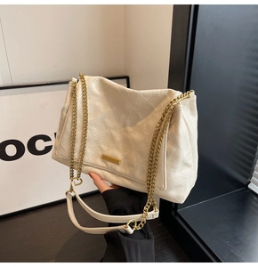 Détail du sac à bandoulière matelassé beige avec chaîne dorée et fermoir métallique