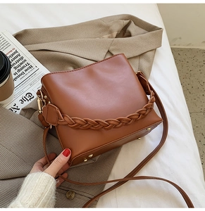 Détails du sac seau marron avec poignée tressée et clous de protection en métal doré