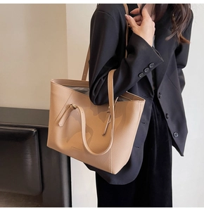 Détail d'un sac cabas camel avec texture grainée et fines lanières d'épaule