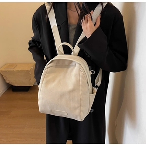 Detail showing the corduroy texture and side pocket of the beige versatile backpack