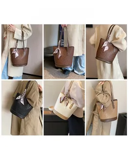 Detail of woven bucket bag texture with silk scarf handle and leather strap