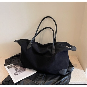 Detailed view of large black corduroy tote with leather reinforced corners and zipper