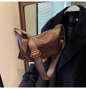 Détail du sac en cuir marron avec bandoulière rétro et fermeture éclair dorée chic