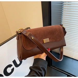 Detail of coffee brown retro baguette bag with matte texture and gold metal buckle