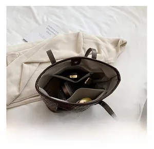 Interior view of brown woven tote bag showing large capacity and multi-pocket storage