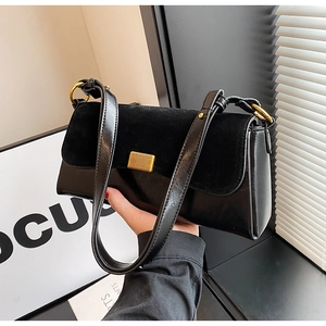 Detail of black contrast textures with suede flap and smooth leather body on underarm bag
