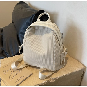 Detailed close-up of cream corduroy texture and side pocket on the casual backpack