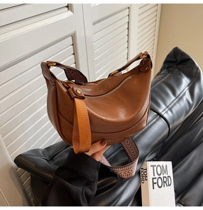 Détail du sac demi-lune marron avec cuir texturé et bandoulière géométrique ethnique