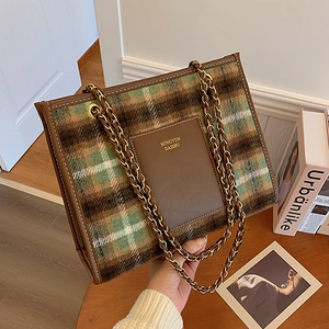 Vintage wool plaid tote bag with golden chain strap and leather details on a wooden table