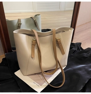 Détails du sac cabas en cuir crème avec bandoulières brunes et logo embossé