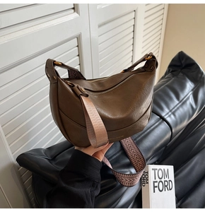 Détail du sac hobo marron foncé avec bandoulière tissée et texture en cuir rétro