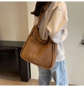 Detailed close-up of large brown canvas tote bag with side pocket for daily commute