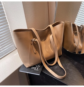 Gros plan sur la texture du cuir litchi marron d'un grand sac cabas avec de longues anses