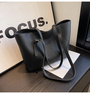 Vue détaillée du grand sac cabas en cuir grainé noir posé sur une table en bois
