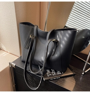 Gros plan du sac cabas en cuir noir avec texture grainée et finitions en métal doré