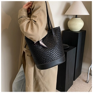 Detail of black woven leather tote bag with decorative scarf and large capacity design