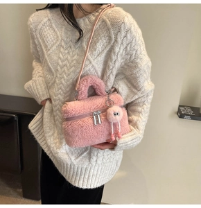 Détail du sac seau en peluche rose avec texture douce et breloque pompon
